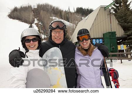 red deer, alberta, canada; three adults at a ski area holding snowboards and skis View Large Photo Image Picture - red deer, alberta, canada; three adults at a ski area holding snowboards and skis. Fotosearch
