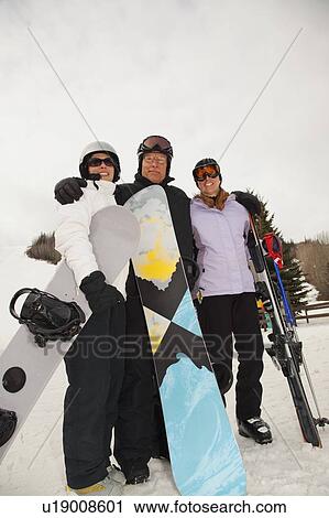 red deer, alberta, canada; three adults at a ski area holding snowboards and skis View Large Photo Image Stock Image - red deer, alberta, canada; three adults at a ski area holding snowboards and skis. Fotosearch