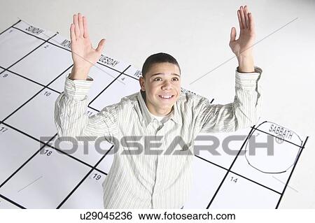 Stock Photograph - teenage boy standing on a calendar. Fotosearch