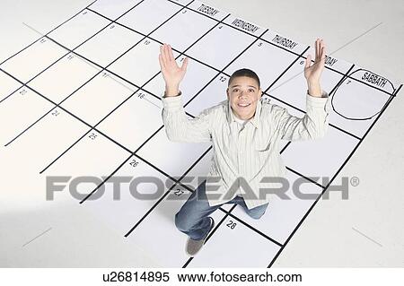 Stock Photography - teenage boy standing on a calendar. Fotosearch