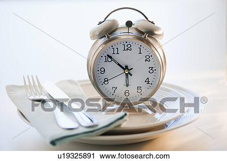 Stock Image - Alarm clock on plate. Fotosearch