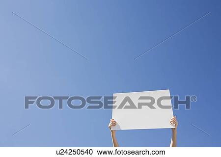 Stock Image - Arms holding a blank placard. Fotosearch