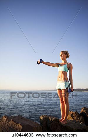 Athletic woman lifting weights outdoors View Large Photo Image Stock Image - Athletic woman lifting weights outdoors. Fotosearch