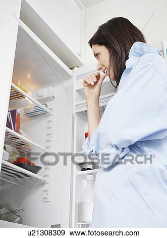Attractive brunette looking in fridge View Large Photo Image Stock Photo - Attractive brunette looking in fridge. Fotosearch