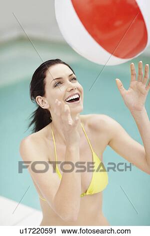 Attractive brunette playing with a beach ball View Large Photo Image Stock Image - Attractive brunette playing with a beach ball. Fotosearch