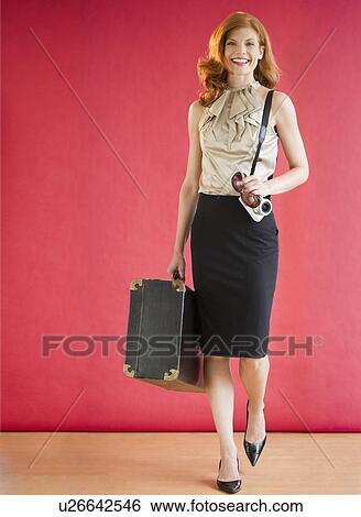 Attractive woman carrying a suitcase View Large Photo Image Stock Photograph - Attractive woman carrying a suitcase. Fotosearch