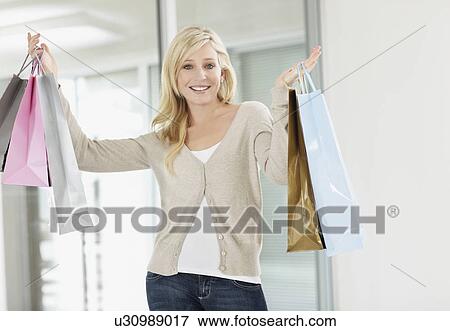 Attractive woman holding shopping bags View Large Photo Image Stock Photo - Attractive woman holding shopping bags. Fotosearch