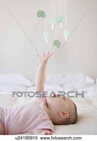 Stock Photography - Baby playing with mobile. Fotosearch