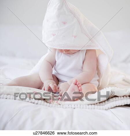 Stock Photograph - Baby wearing hooded towel. Fotosearch