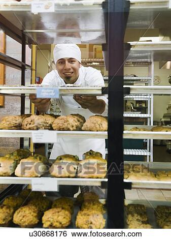 Baker standing behind trays of baked goods View Large Photo Image Stock Photograph - Baker standing behind trays of baked goods. Fotosearch