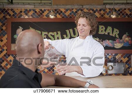 Bartender pouring drink at juice bar View Large Photo Image Stock Image - Bartender pouring drink at juice bar. Fotosearch