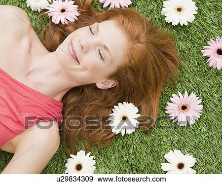 Stock Photo - Beautiful woman relaxing on grass. Fotosearch