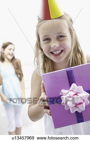 Birthday girl holding a gift View Large Photo Image Stock Photo - Birthday girl holding a gift. Fotosearch