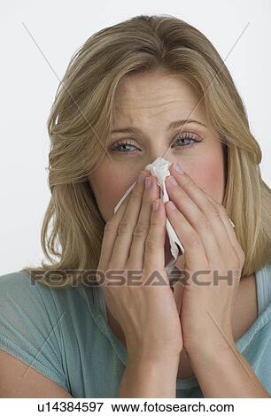 Stock Photo - Blond woman blowing her nose. Fotosearch