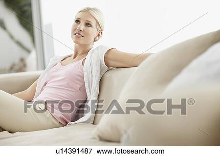Blond woman daydreaming on couch View Large Photo Image Stock Photo - Blond woman daydreaming on couch. Fotosearch