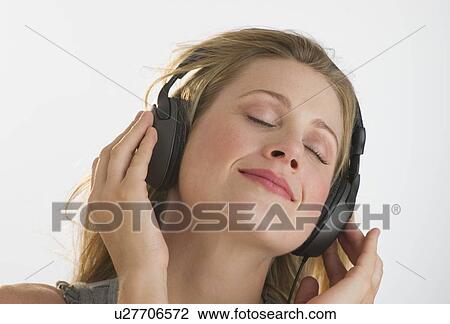 Blond woman listening to music with headphones View Large Photo Image Stock Image - Blond woman listening to music with headphones. Fotosearch