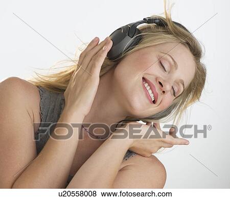 Blond woman listening to music with headphones View Large Photo Image Stock Photo - Blond woman listening to music with headphones. Fotosearch