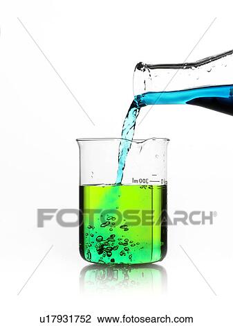 Stock Image - Blue liquid being poured into measuring cup. Fotosearch