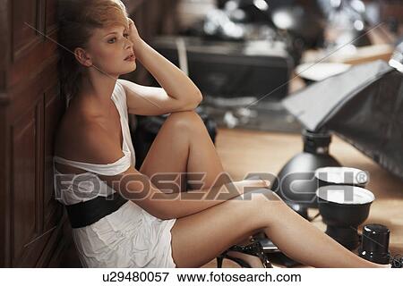 Stock Photo - Bored fashion model sitting on floor. Fotosearch
