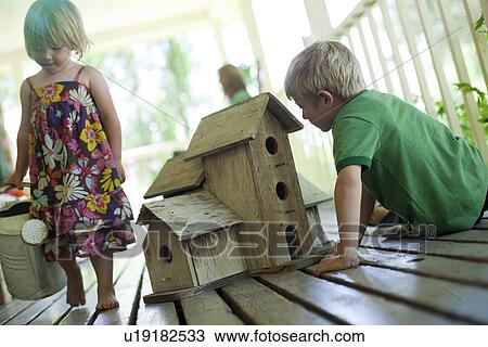 Stock Image - Brother and sister on porch. Fotosearch