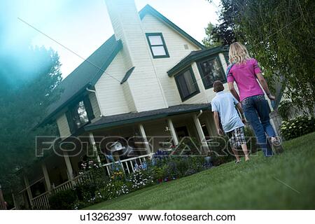 Stock Photo - Brother and sister walking towards house. Fotosearch