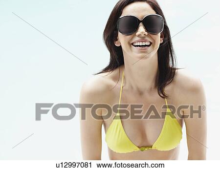 Stock Image - Brunette wearing bikini and sunglasses. Fotosearch