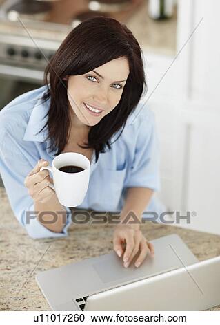 Stock Image - Brunette woman drinking coffee. Fotosearch