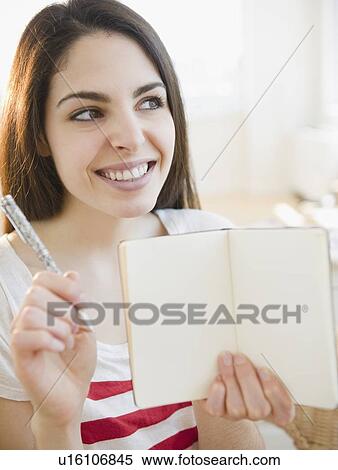 Brunette woman holding an empty notebook View Large Photo Image Stock Photography - Brunette woman holding an empty notebook. Fotosearch