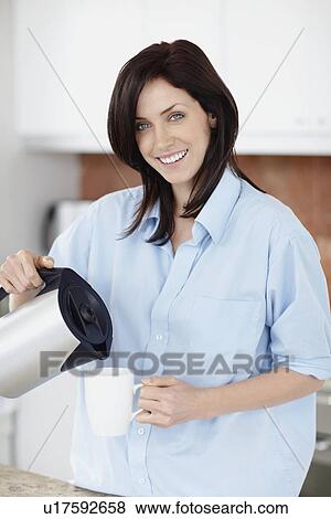 Stock Photo - Brunette woman pouring coffee. Fotosearch