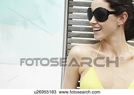 Stock Image - Brunette woman sunbathing. Fotosearch