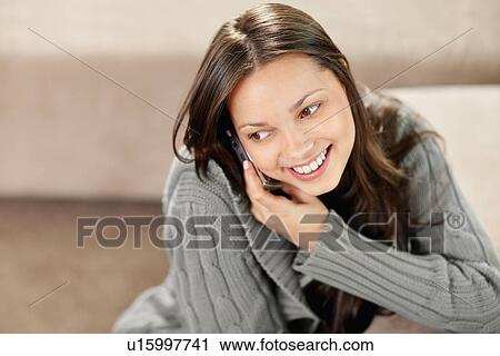 Stock Image - Brunette woman talking on phone. Fotosearch