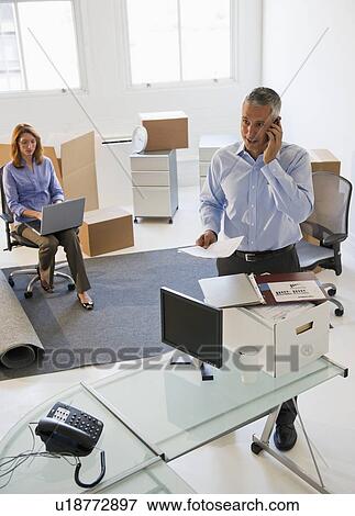 Stock Photo - Business entrepreneurs working in startup office. Fotosearch