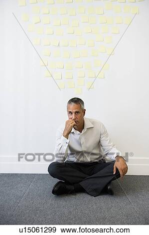 Businessman sitting behind wall covered in sticky notes View Large Photo Image Stock Photo - Businessman sitting behind wall covered in sticky notes. Fotosearch