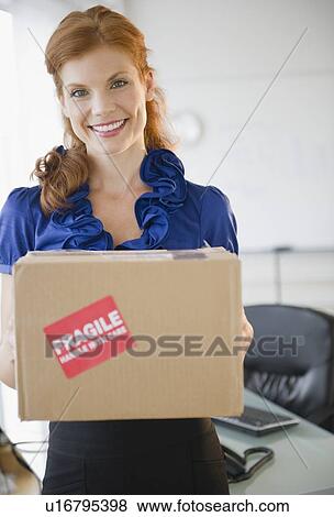 Stock Photo - Businesswoman holding a package. Fotosearch