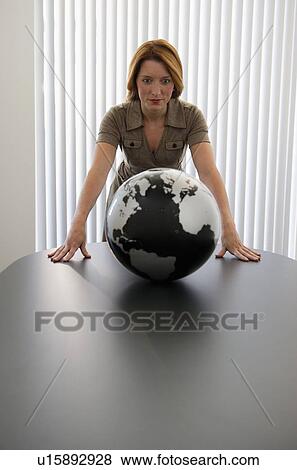 Stock Photo - Businesswoman looking at globe. Fotosearch