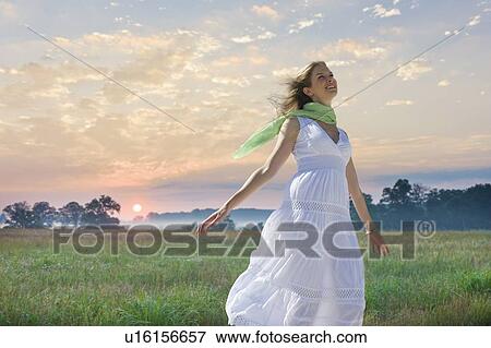 Carefree woman in field View Large Photo Image Stock Photo - Carefree woman in field. Fotosearch