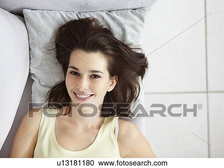 Cheerful brunette woman relaxing on couch View Large Photo Image Stock Image - Cheerful brunette woman relaxing on couch. Fotosearch