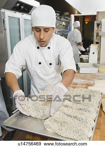 Stock Photo - Chef making bread in bakery. Fotosearch