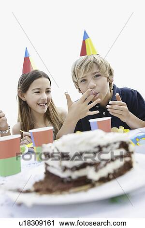Stock Image - Children eating birthday cake. Fotosearch