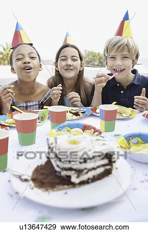 Stock Photo - Children eating birthday cake. Fotosearch
