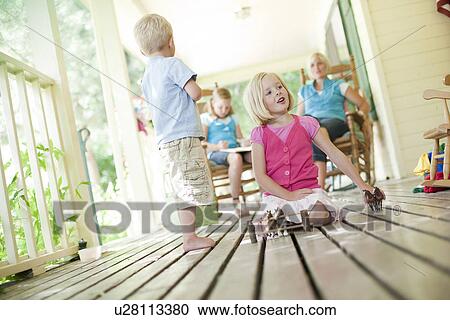 Stock Image - Children playing on porch. Fotosearch