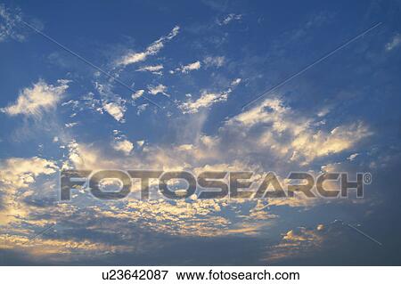 Stock Photo - Clouds in blue sky at dusk. Fotosearch
