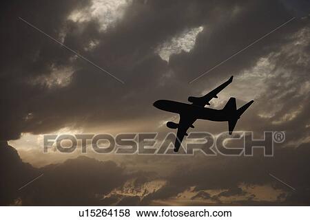 Commercial jet in cloudy sky View Large Photo Image Stock Photo - Commercial jet in cloudy sky. Fotosearch