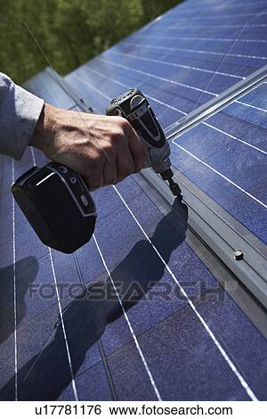 Construction worker installing solar panel on roof View Large Photo Image Stock Photograph - Construction worker installing solar panel on roof. Fotosearch