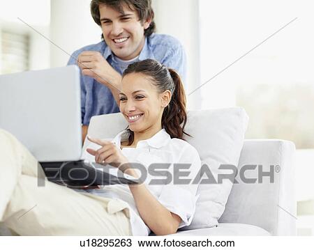 Stock Image - Couple looking at laptop. Fotosearch