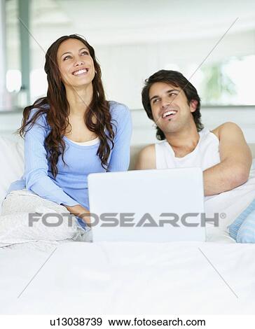 Couple looking at laptop together View Large Photo Image Stock Photo - Couple looking at laptop together. Fotosearch