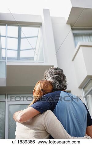 Couple looking at the their home View Large Photo Image Stock Photograph - Couple looking at the their home. Fotosearch