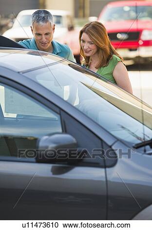 Stock Image - Couple shopping for a new car. Fotosearch