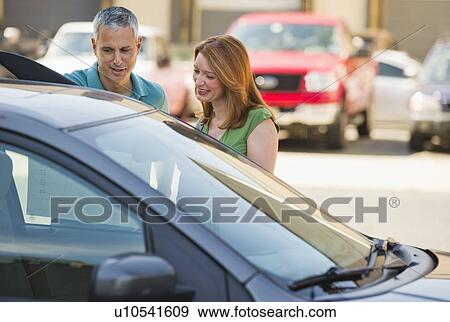 Couple shopping for a new car View Large Photo Image Stock Photo - Couple shopping for a new car. Fotosearch