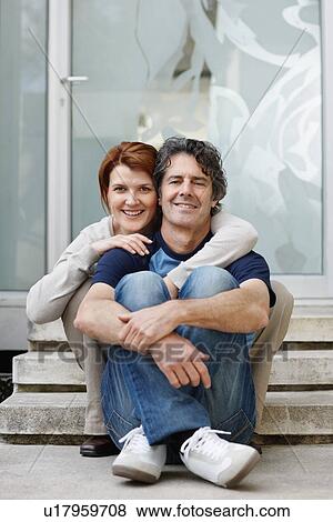 Couple sitting on steps in front of their home View Large Photo Image Stock Photo - Couple sitting on steps in front of their home. Fotosearch